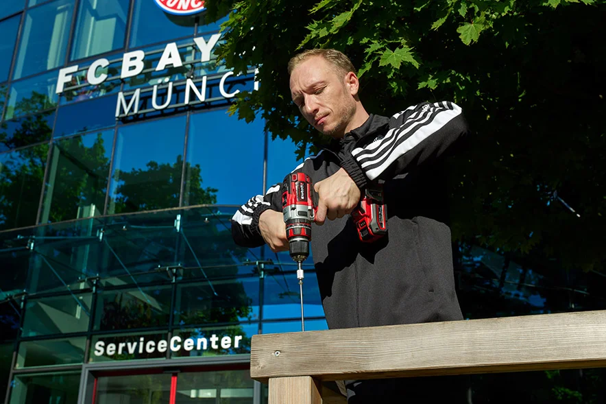 Person baut Holzrahmen mit Akkuschrauber